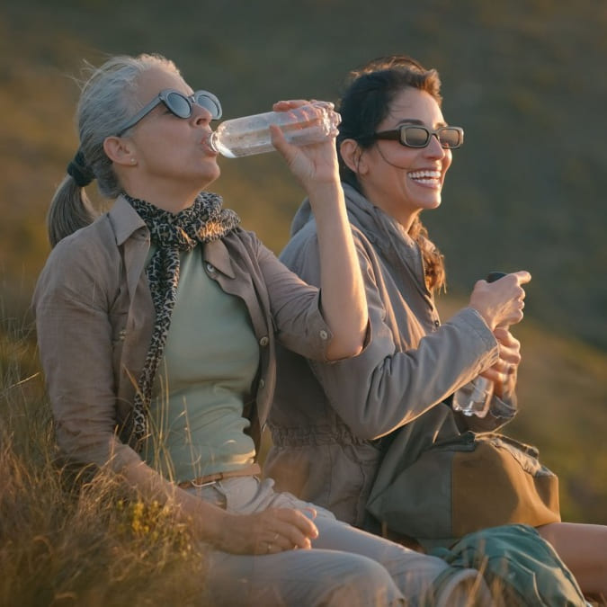 Deux femmes qui ont sûrement fait une randonnée. Elles rigolent ensemble et cette image fait référence au patch ménopause